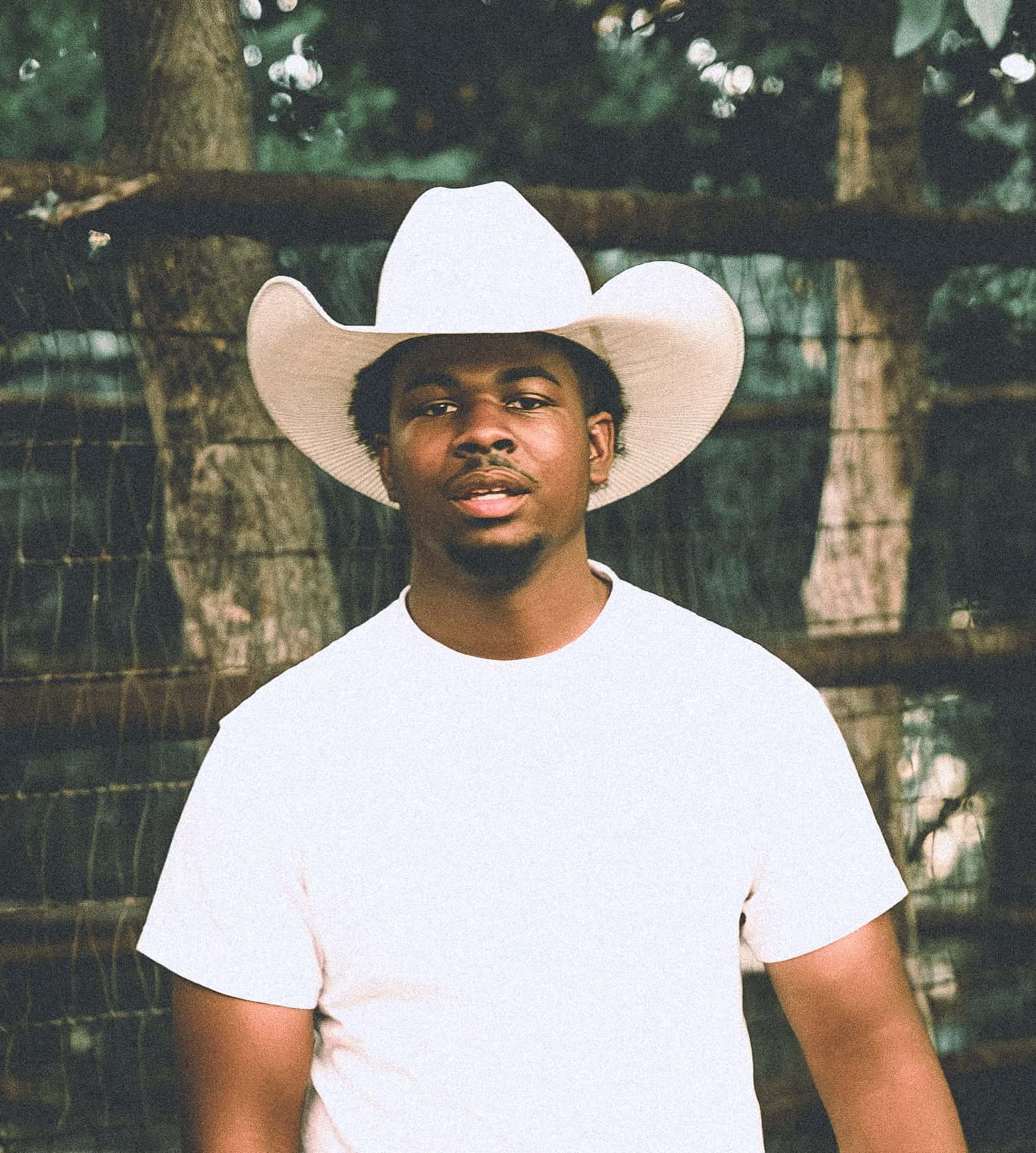 Portrait — white cowboy hat, wire fence